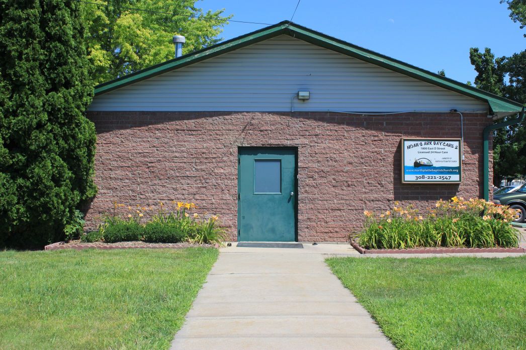 The brick entrance of Noah's Ark Daycare 2 on East D Street, framed by day lilies