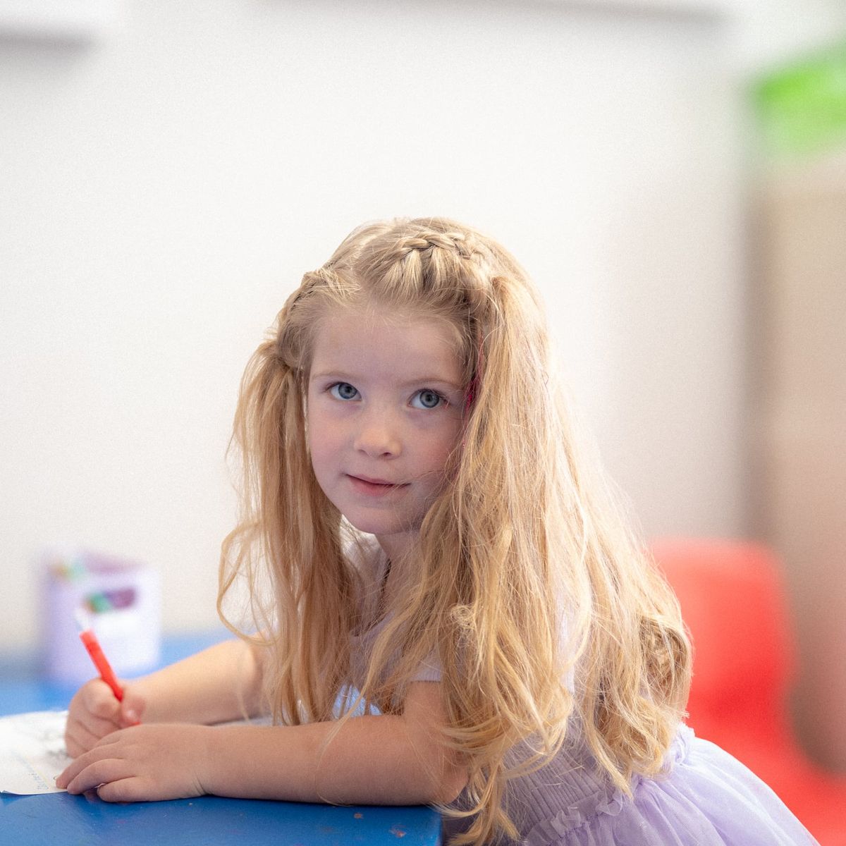 A girl coloring at a classroom table at Noah's Ark Daycare